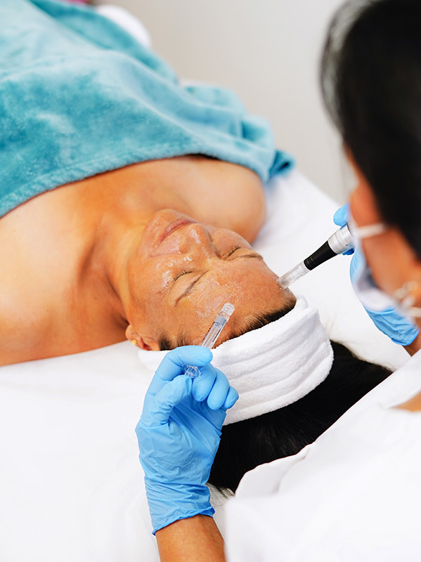 A gloved esthetician performing a facial treatment